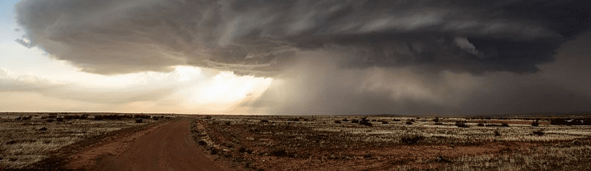 A desert landscape with dark clouds in the background.